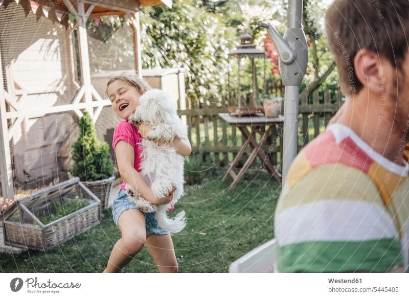 Mädchen spielt mit Hund im Garten Hunde spielen lachen glücklich Glück glücklich sein glücklichsein Gärten Gaerten entspannt entspanntheit relaxt weiblich