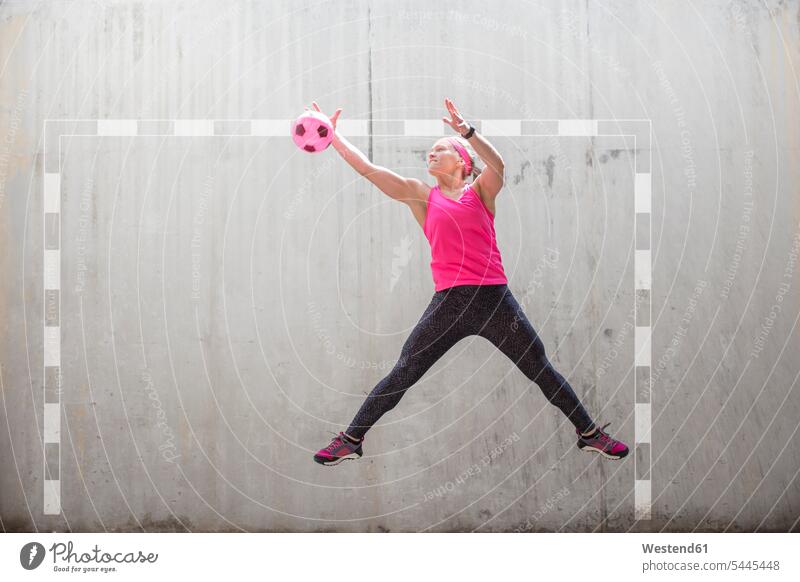 Frau springt, um einen Ball zu fangen weiblich Frauen fangend Bälle springen hüpfen Erwachsener erwachsen Mensch Menschen Leute People Personen Sprung Spruenge