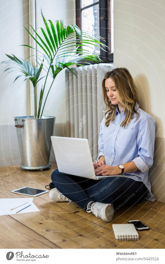 Frau sitzt zu Hause mit Laptop auf dem Boden sitzen sitzend Notebook Laptops Notebooks weiblich Frauen Zuhause daheim benutzen Böden Boeden Computer Rechner