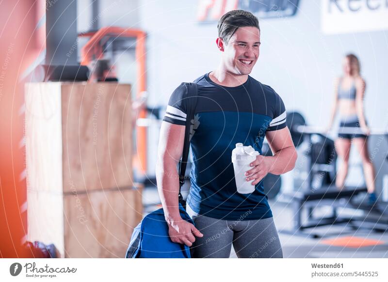 Lächelnder junger Mann in Turnhalle Pause trainieren Fitnessstudio Fitnessclubs Fitnessstudios lächeln Männer männlich fit Gesundheit gesund Sport Erwachsener