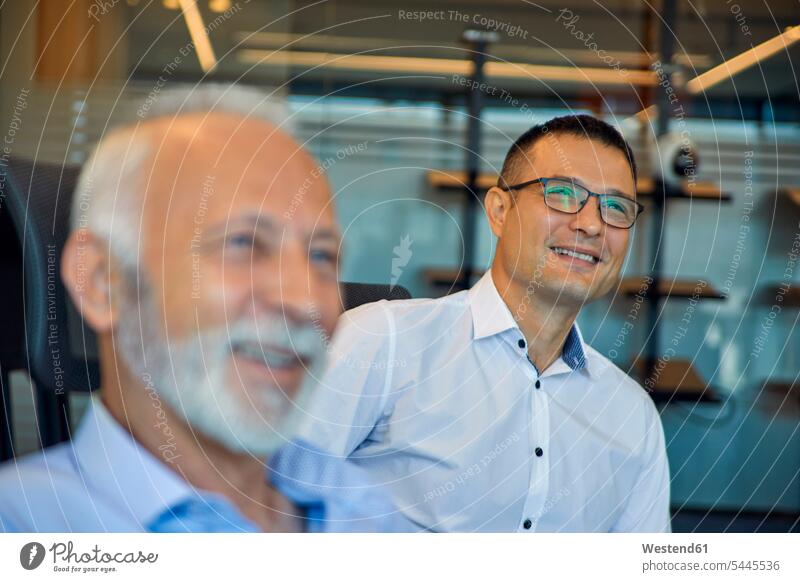 Zwei lächelnde Geschäftsmänner im Amt Kollegen Arbeitskollegen Büro Office Büros Geschäftsmann Businessmann Businessmänner Meeting Business Meeting Arbeitsplatz