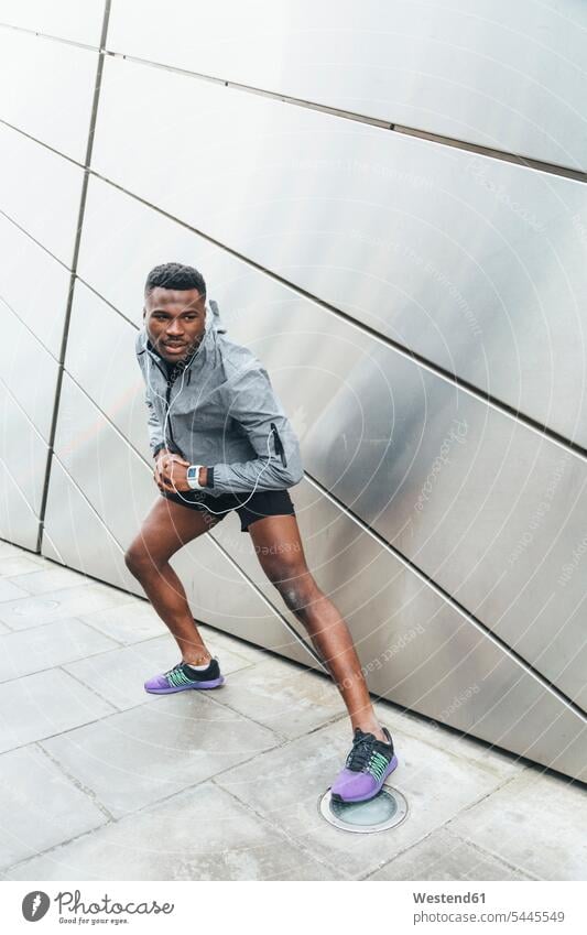 Athlet streckt sich an der Gebäudefront Joggen Jogging Mann Männer männlich trainieren dehnen strecken Fitness fit Gesundheit gesund Sport Erwachsener erwachsen