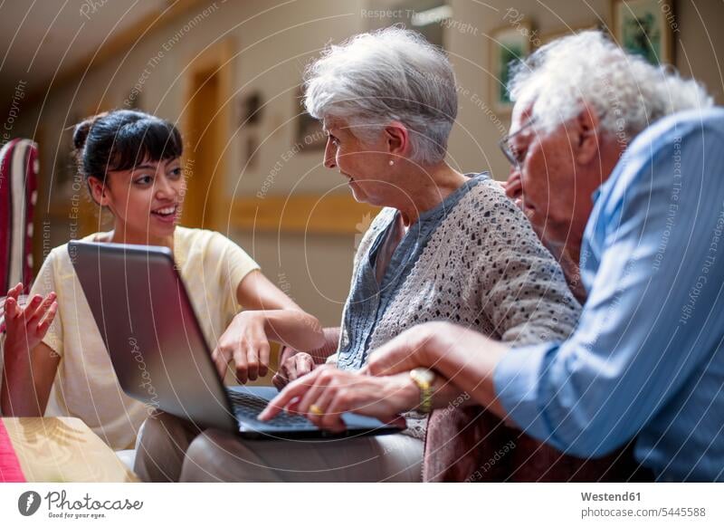 Krankenschwester unterrichtet Senioren im Altenheim, wie man einen Laptop benutzt Notebook Laptops Notebooks Neugier Neugierde neugierig Laptop benutzen