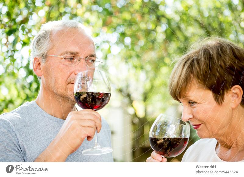 Älteres Ehepaar trinkt ein Glas Rotwein im Freien riechen Paar Pärchen Paare Partnerschaft Wein Weine Mensch Menschen Leute People Personen Alkohol