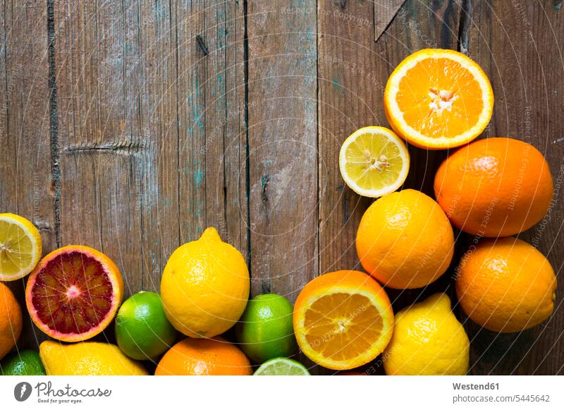 In Scheiben geschnittene und ganze Zitronen, Orangen und Limetten auf Holz vitaminreich Blutorange Blutorangen Variation verschieden Abweichung Variationen
