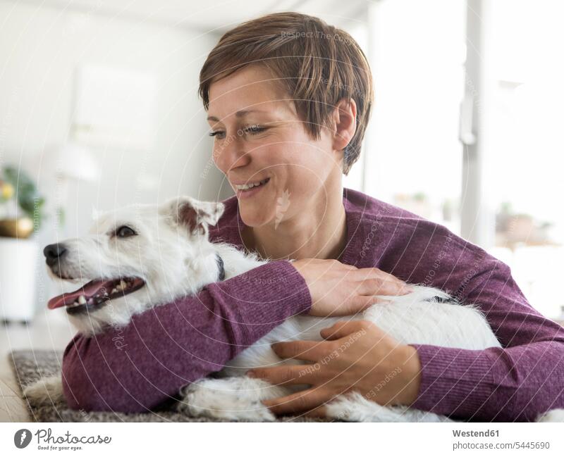 Frau umarmt ihren Hund zu Hause Hunde weiblich Frauen Haustier Haustiere Tier Tierwelt Tiere Erwachsener erwachsen Mensch Menschen Leute People Personen lächeln