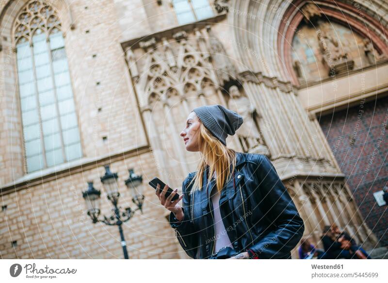 Spanien, Barcelona, junge Frau mit Mobiltelefon, die etwas beobachtet weiblich Frauen Erwachsener erwachsen Mensch Menschen Leute People Personen Touristin