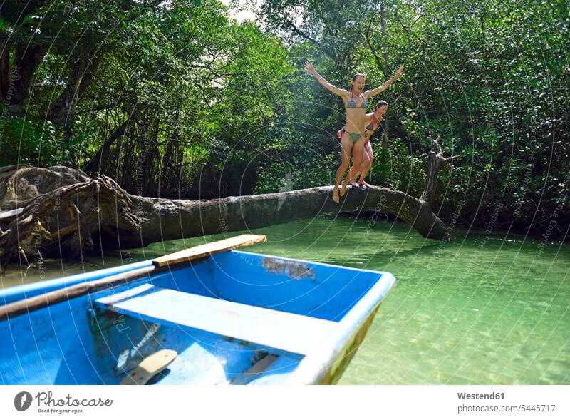 Dominikanische Republik, Samana, zwei Frauen springen in einer Mangrovenlagune ins Wasser Freundinnen hüpfen weiblich Boot Boote Freunde Freundschaft