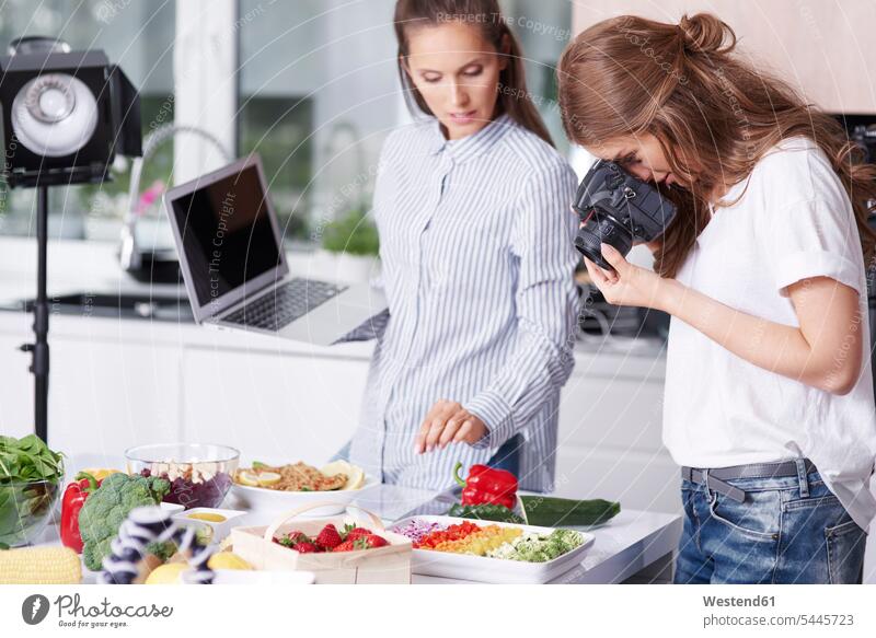 Frau fotografiert Essen in der Küche Rechner Laptops Notebook Notebooks Fotokamera Kamera Kameras Küchen Leute Menschen People Person Personen erwachsen