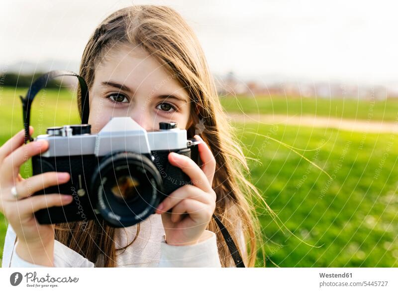 Porträt eines Mädchens, das eine altmodische Kamera im Freien hält weiblich Fotoapparat Fotokamera Portrait Porträts Portraits fotografieren Kind Kinder Kids