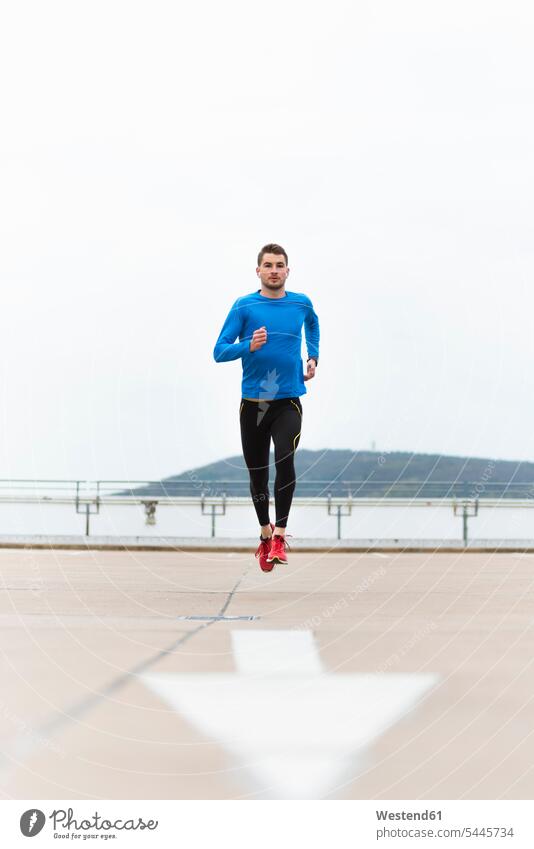 Junger Mann rennt auf Parkebene Joggen Jogging trainieren laufen rennen Männer männlich Fitness fit Gesundheit gesund Sport Erwachsener erwachsen Mensch