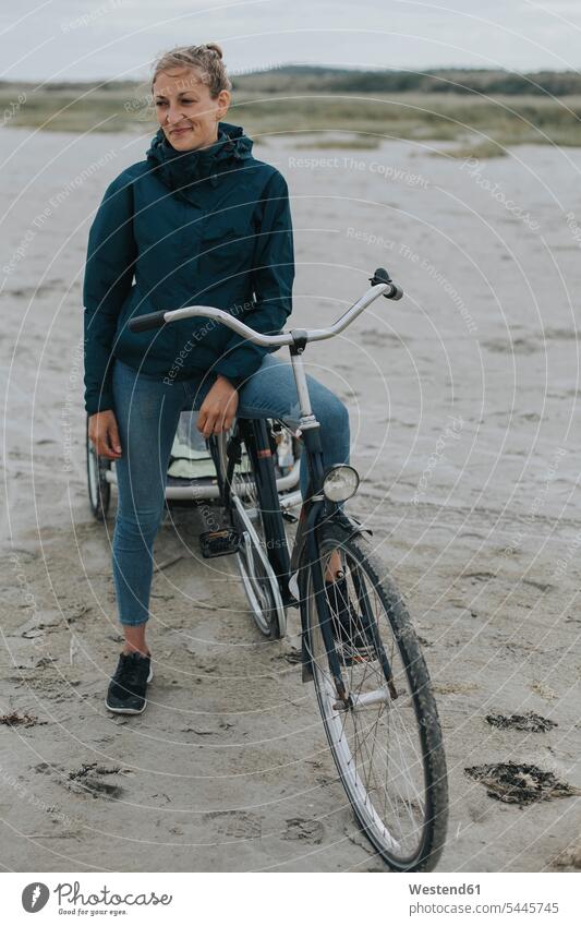 Niederlande, Schiermonnikoog, Frau mit Fahrrad und Anhänger am Strand Beach Straende Strände Beaches Bikes Fahrräder Räder Rad weiblich Frauen Raeder