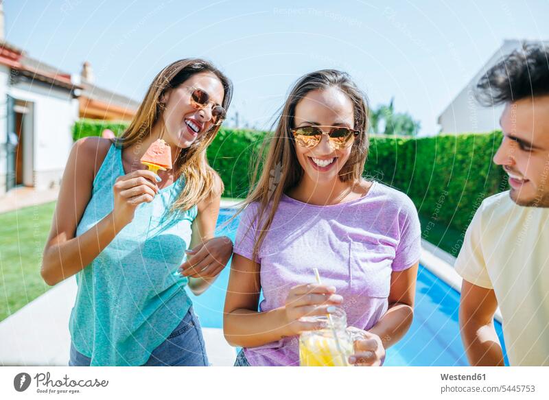 Glückliche Freunde mit Getränk und Wassermelone am Pool entspannt entspanntheit relaxt lächeln glücklich glücklich sein glücklichsein Freundschaft Kameradschaft