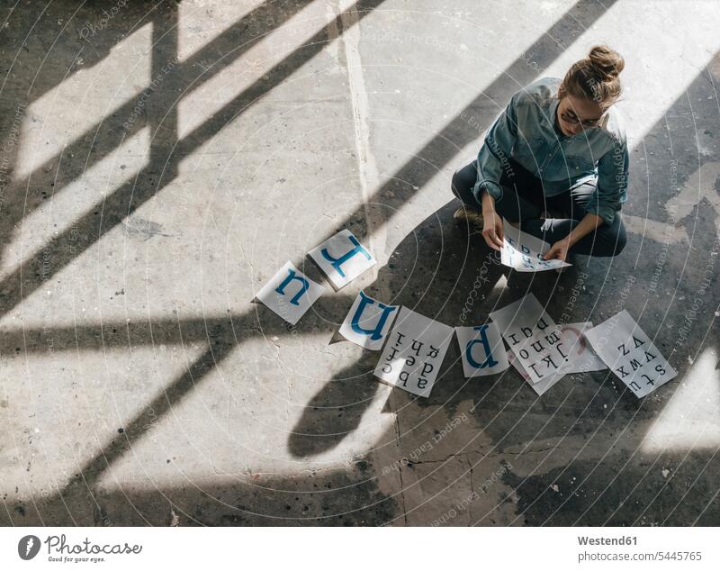 Junge Frau sitzt auf Betonboden und arbeitet an Briefvorlagen arbeiten Arbeit Sonnenschein sonnig weiblich Frauen Erwachsener erwachsen Mensch Menschen Leute
