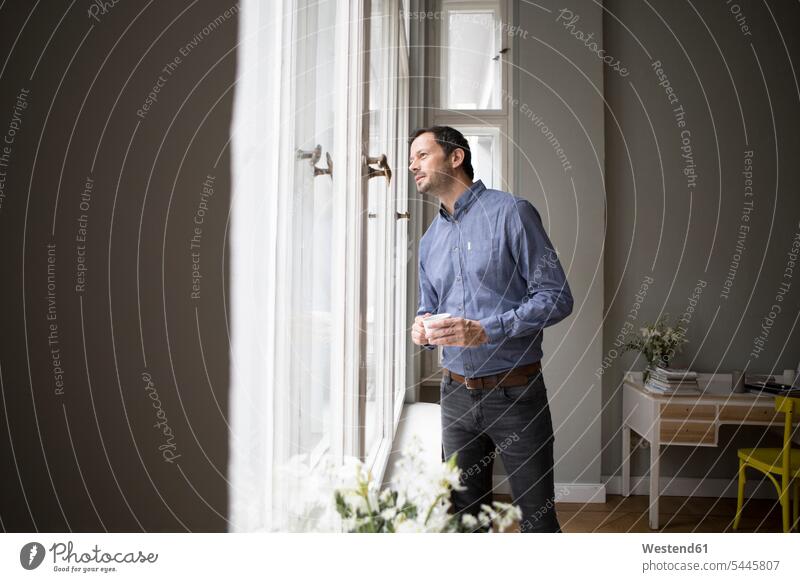 Mann, der durch ein Fenster schaut und etwas beobachtet schauen sehend beobachten zuschauen ansehen Männer männlich Erwachsener erwachsen Mensch Menschen Leute