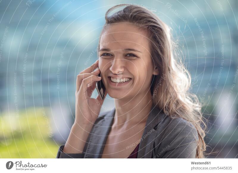 Porträt einer jungen Geschäftsfrau Frau weiblich Frauen telefonieren anrufen Anruf telephonieren lächeln Karriere Portrait Porträts Portraits Geschäftsfrauen