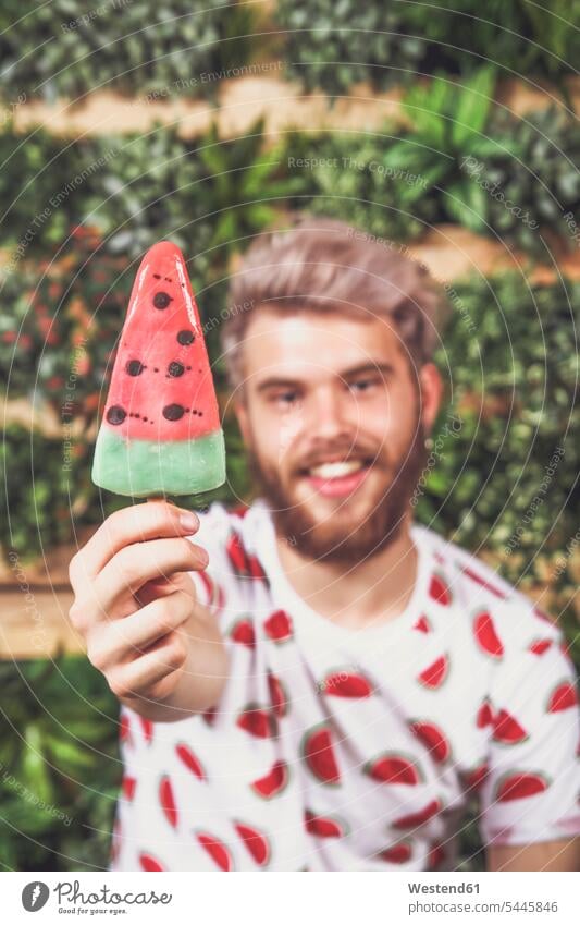 Junger Mann bietet Wassermeloneneis-Lolly an, Nahaufnahme Männer männlich Hand Hände anbieten Eis Speiseeis Erwachsener erwachsen Mensch Menschen Leute People
