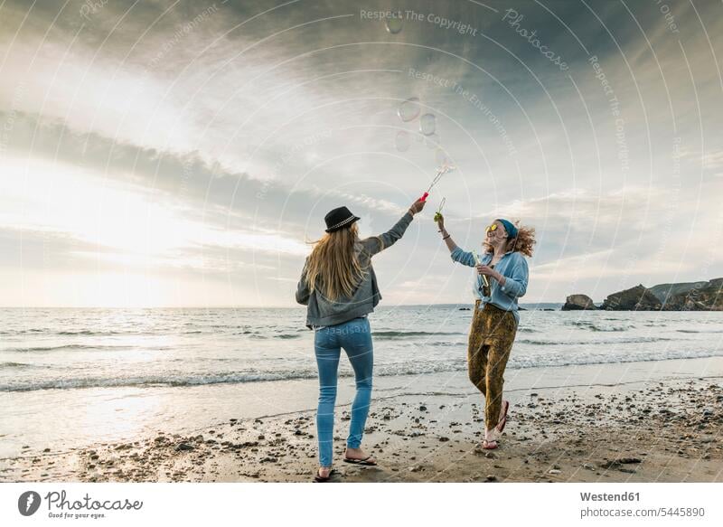 Glückliche Freunde machen Seifenblasen am Strand Beach Straende Strände Beaches glücklich glücklich sein glücklichsein Freundinnen Freundschaft Kameradschaft