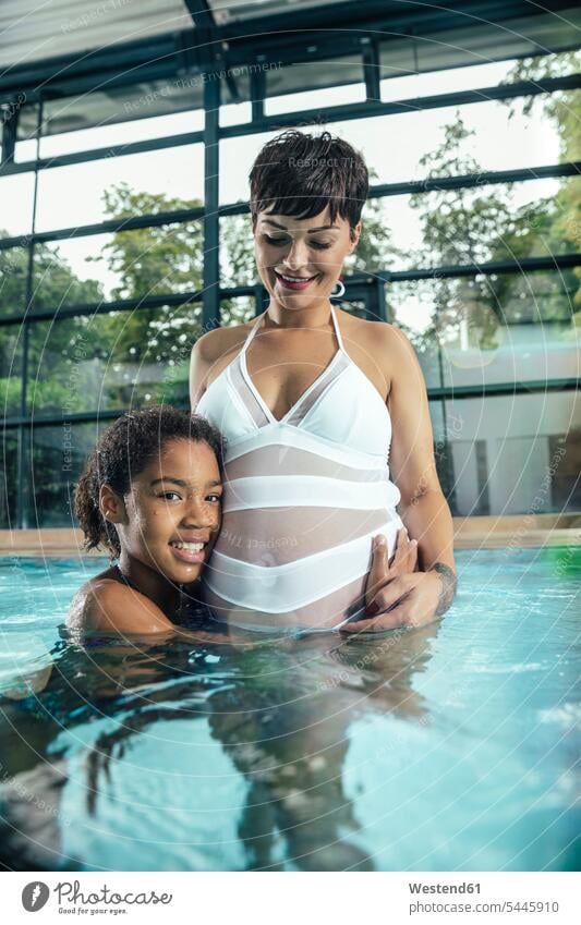 Mädchen mit ihrer schwangeren Mutter im Hallenbad Hallenbäder Hallenbaeder weiblich Tochter Töchter Schwimmbad Schwimmbaeder Schwimmbäder Mami Mutti Mütter Mama
