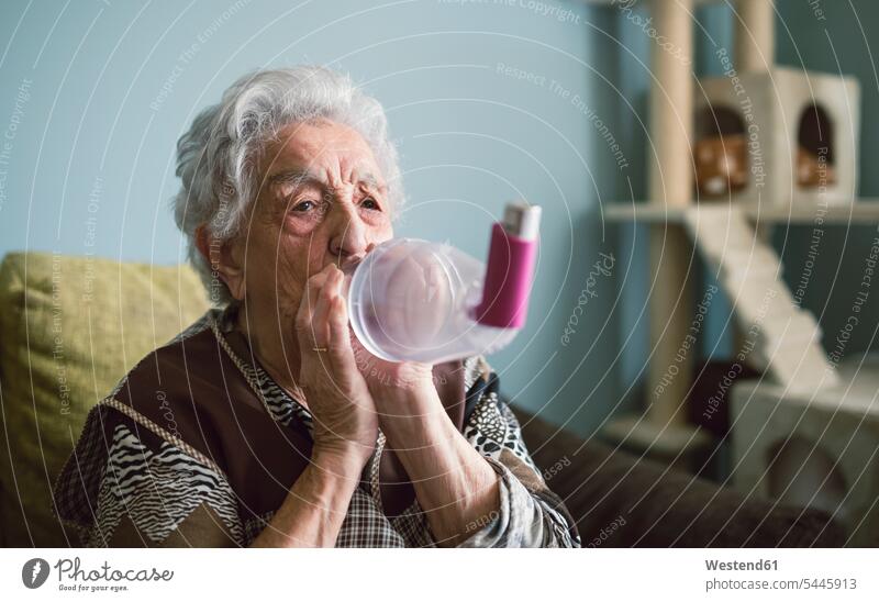 Ältere Frau benutzt Inhalator zu Hause Seniorin älter Seniorinnen alt inhalieren Inhalation Inhalationsapparat Inhalationsapparate Inhaliergeräte Inhalatoren