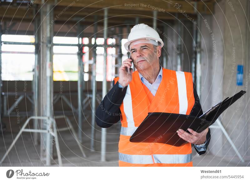 Mann am Telefon mit Sicherheitsweste in einem im Bau befindlichen Gebäude telefonieren anrufen Anruf telephonieren Männer männlich Architekt Architekten