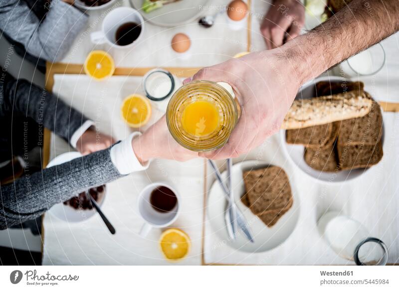 Vater schenkt Kind ein Glas Orangensaft Apfelsinensaft O-Saft Frühstück frühstücken geben überreichen Familie Familien Trinkgläser Gläser Trinkglas Fruchtsaft