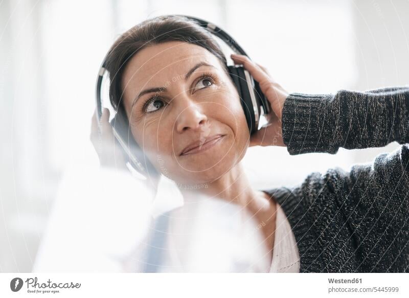 Porträt einer lächelnden Frau, die mit Kopfhörern Musik hört Kopfhoerer Portrait Porträts Portraits weiblich Frauen Erwachsener erwachsen Mensch Menschen Leute