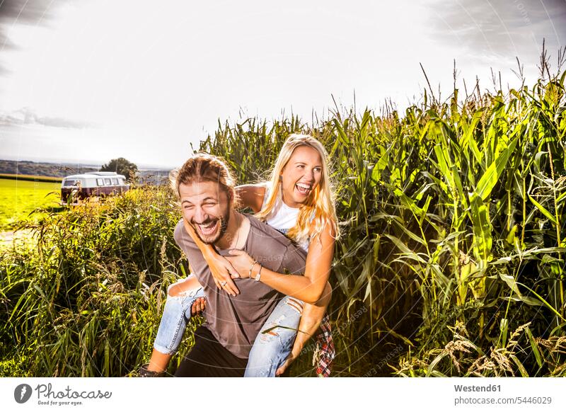 Sorgenfreies Paar im Maisfeld Spaß Spass Späße spassig Spässe spaßig ländlich auf dem Land auf dem Lande Pärchen Paare Partnerschaft Kleinbus Kleinbusse lachen