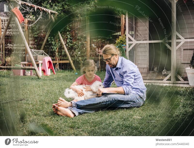 Vater liest Buch mit Tochter im Garten Töchter entspannt entspanntheit relaxt Bücher lesen Lektüre Papas Väter Vati Vatis Papis Gärten Gaerten Kind Kinder