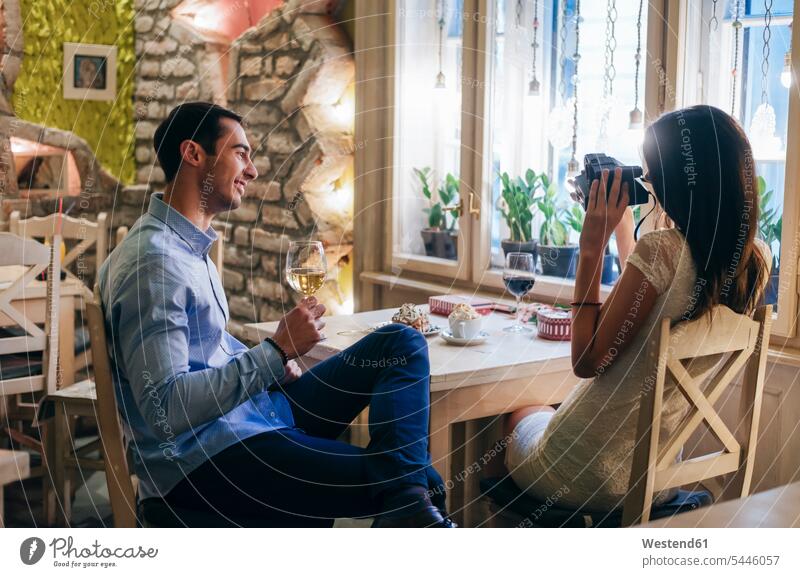 Junges Paar macht Sofortbilder in einem Restaurant Pärchen Paare Partnerschaft fotografieren Lokal Speiserestaurant Lokale Speiselokale Restaurants