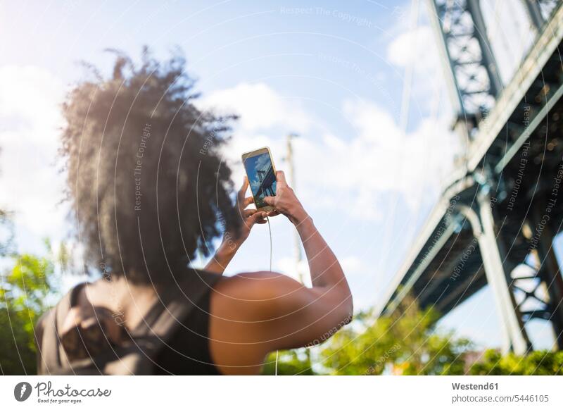 USA, New York City, Brooklyn, Frau macht Handyfoto von der Manhattan Bridge fotografieren weiblich Frauen Mobiltelefon Handies Handys Mobiltelefone Erwachsener