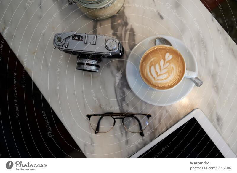 Blick von oben auf eine Kaffeetasse, analoge Kamera und Gläser auf einem Marmortisch Milchschaum Erreichbarkeit verfügbar Verfügbarkeit erreichbar
