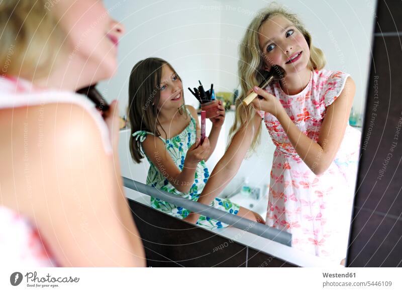 Zwei Mädchen schminken sich im Badezimmer weiblich Spiegel lächeln Freundinnen Kind Kinder Kids Mensch Menschen Leute People Personen Freunde Freundschaft