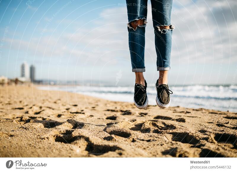 Spanien, Barcelona, Beine eines jungen Mannes, der am Strand in die Luft springt Beach Straende Strände Beaches springen hüpfen Mensch Menschen Leute People