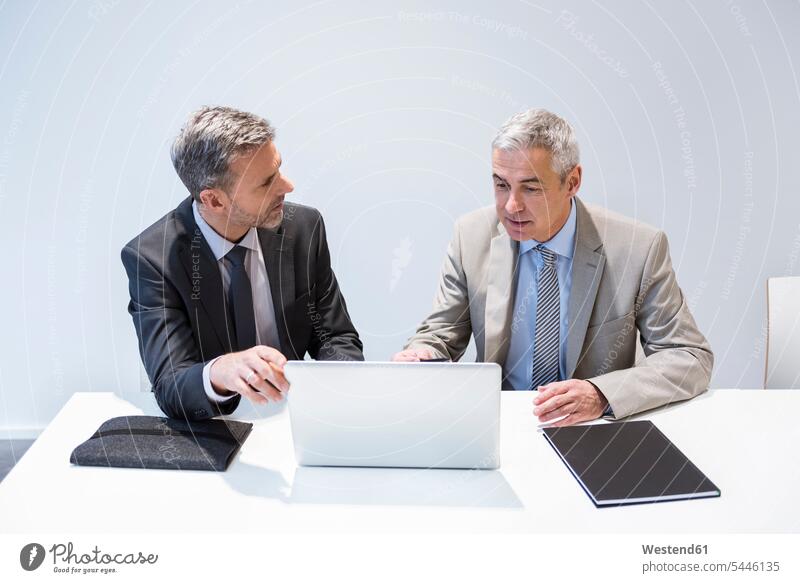 Zwei Geschäftsleute arbeiten im Amt zusammen Laptop Notebook Laptops Notebooks Arbeit sitzen sitzend sitzt Büro Office Büros besprechen diskutieren Besprechung