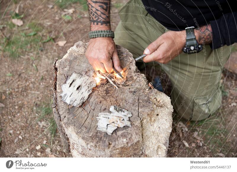 Mann entzündet Feuer an Baumstumpf im Wald Tattoo Tätowierungen Tatoos Taetowierung Tattoos Taetowierungen anzünden Männer männlich Forst Wälder tätowiert Style