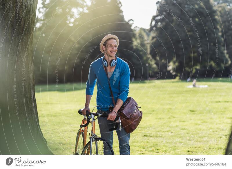 Porträt eines entspannten Mannes mit Rennrad in einem Park Männer männlich Parkanlagen Parks Erwachsener erwachsen Mensch Menschen Leute People Personen Hut