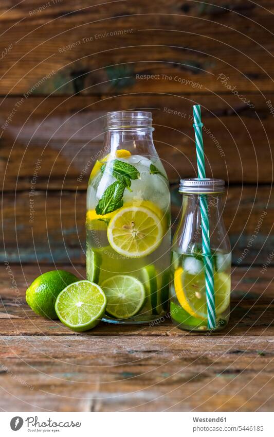 Glasflaschen mit Aufgusswasser mit Zitrone, Limette, Minzeblättern und Eiswürfeln eisgekühlt eisgekuehlt eisgekühlte angerichtet garniert Frucht Früchte