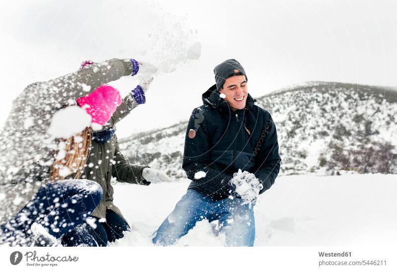 Freunde bei einer Schneeballschlacht im Schnee spielen Winter winterlich Winterzeit Freundschaft Kameradschaft lachen Schneeballschlachten werfen Wurf Wetter