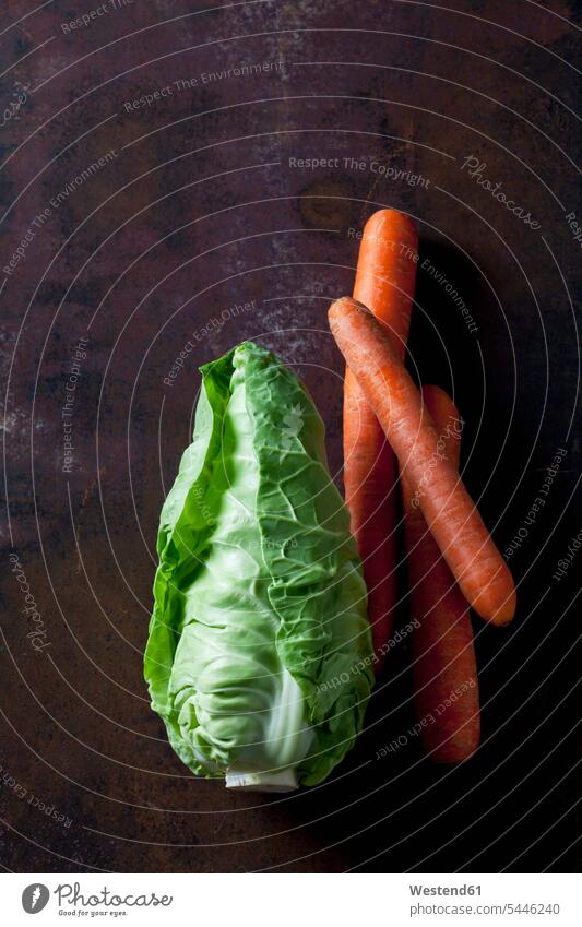 Liebeskohl und Karotten auf dunklem Hintergrund Textfreiraum Studioaufnahme Studioaufnahmen Gesunde Ernährung Ernaehrung Gesunde Ernaehrung Gesundheit gesund