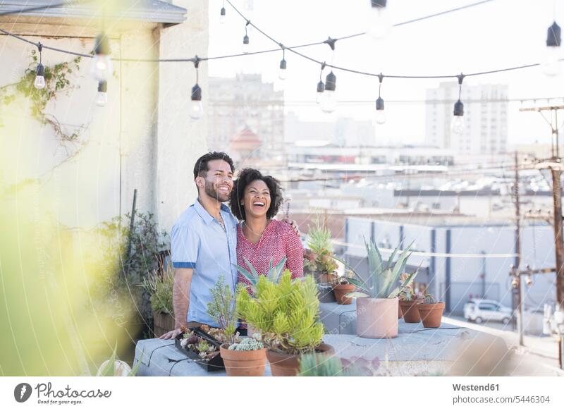 Ehepaar steht in ihrem Dachgarten gärtnern Gartenarbeit Gartenbau Dachterrasse Dachterrassen stehen stehend glücklich Glück glücklich sein glücklichsein Paar
