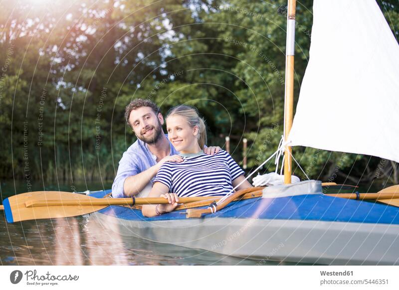 Ein glückliches junges Paar genießt eine Kanufahrt mit Segel Kanus Pärchen Paare Partnerschaft Glück glücklich sein glücklichsein Ausflug Ausflüge Kurzurlaub