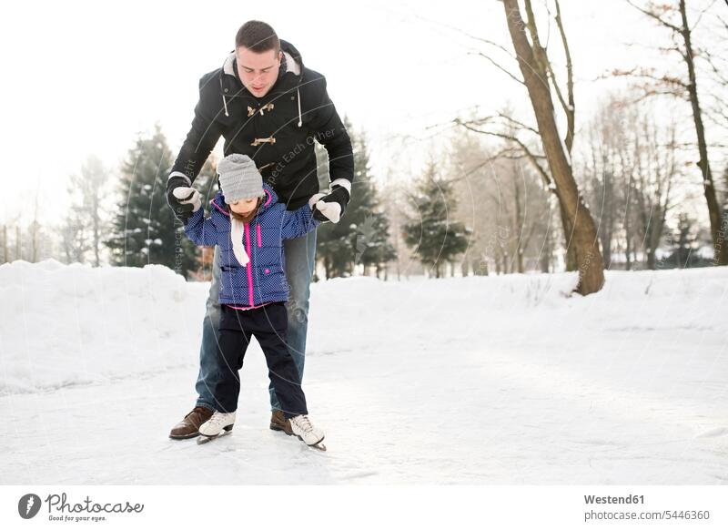 Vater und Tochter eislaufen auf gefrorenem See Töchter Papas Väter Vati Vatis Papis vereist eingefroren zugefroren schlittschuhlaufen Konzentration konzentriert