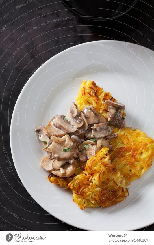 Kartoffelrost mit Champignons in Sahnesoße auf dem Teller Draufsicht Vogelperspektive von oben Aufsicht Schweizer Küche Schweizer Essen Rahmsauce Spezialität