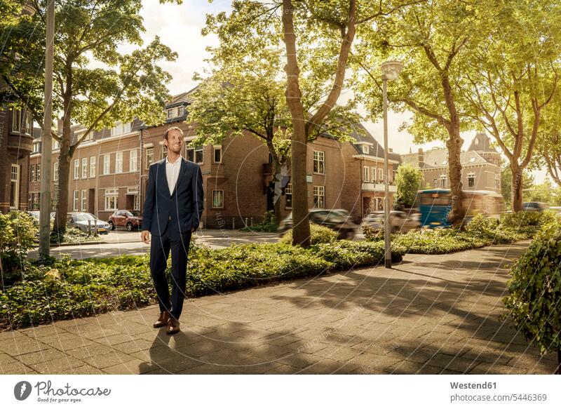 Niederlande, Venlo, selbstbewusster Geschäftsmann auf dem Bürgersteig stehend steht Stadt staedtisch städtisch Businessmann Businessmänner Geschäftsmänner