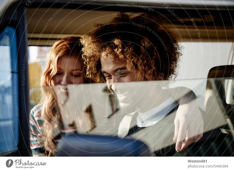 Glückliches junges Paar in einem Auto Wagen PKWs Automobil Autos glücklich glücklich sein glücklichsein Pärchen Paare Partnerschaft Kraftfahrzeug Verkehrsmittel