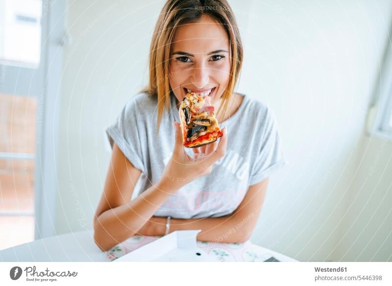 Porträt einer jungen Frau, die zu Hause Pizza isst weiblich Frauen Pizzen essen essend Erwachsener erwachsen Mensch Menschen Leute People Personen Essen Food