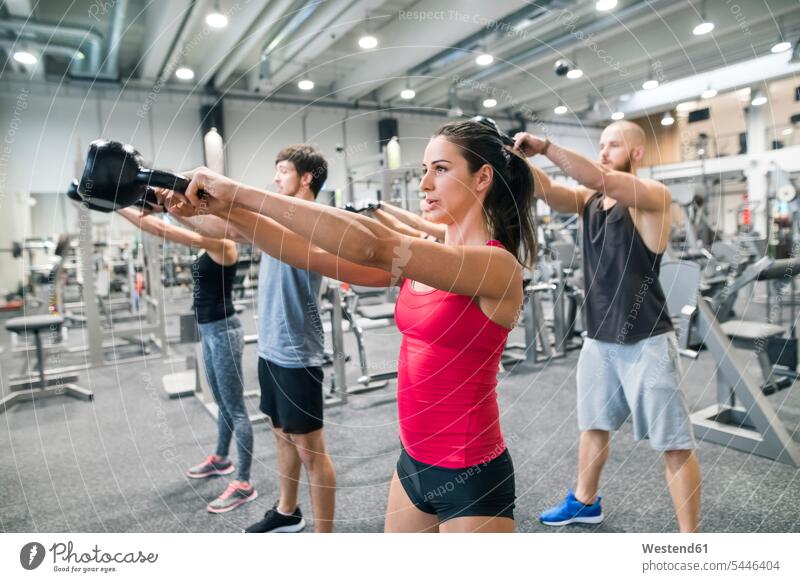 Gruppe von Sportlern, die mit Kettlebells in der Turnhalle trainieren Fitnessstudio Fitnessclubs Fitnessstudios fit Gesundheit gesund vier Personen 4 4 Personen