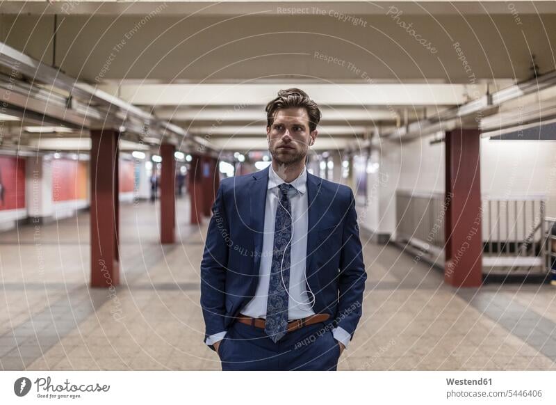 Geschäftsmann geht in U-Bahn-Station mit Händen in den Taschen attraktiv schoen gut aussehend schön Attraktivität gutaussehend hübsch Businessmann