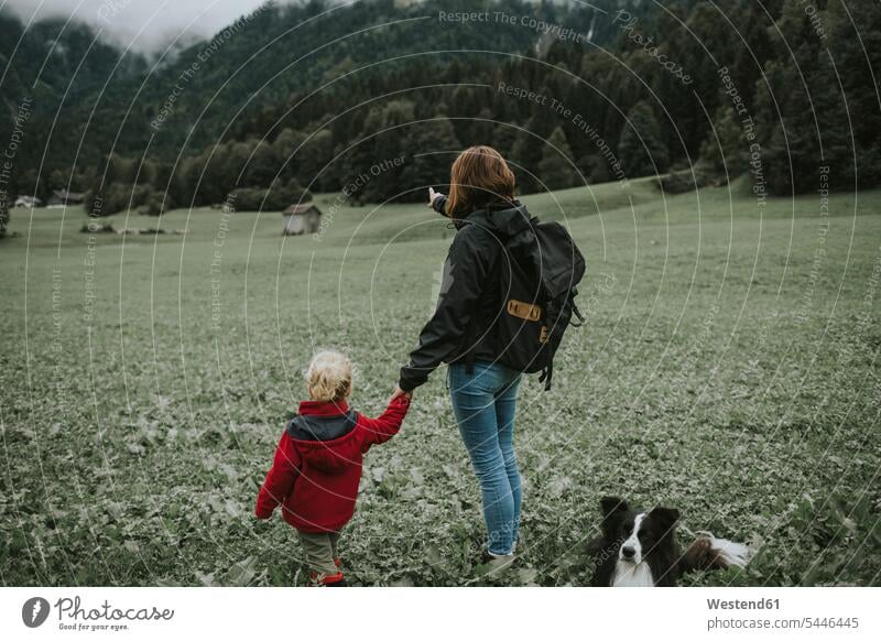 Österreich, Vorarlberg, Mellau, Mutter und Kleinkind mit Hund auf einem Ausflug in die Berge stehen stehend steht Hunde Mami Mutti Mütter Mama Wald Forst Wälder